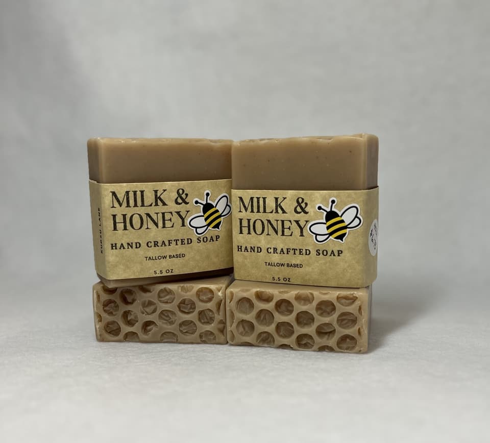 Two Milk & Honey bars with honeycomb-textured tops in yellow bee labels