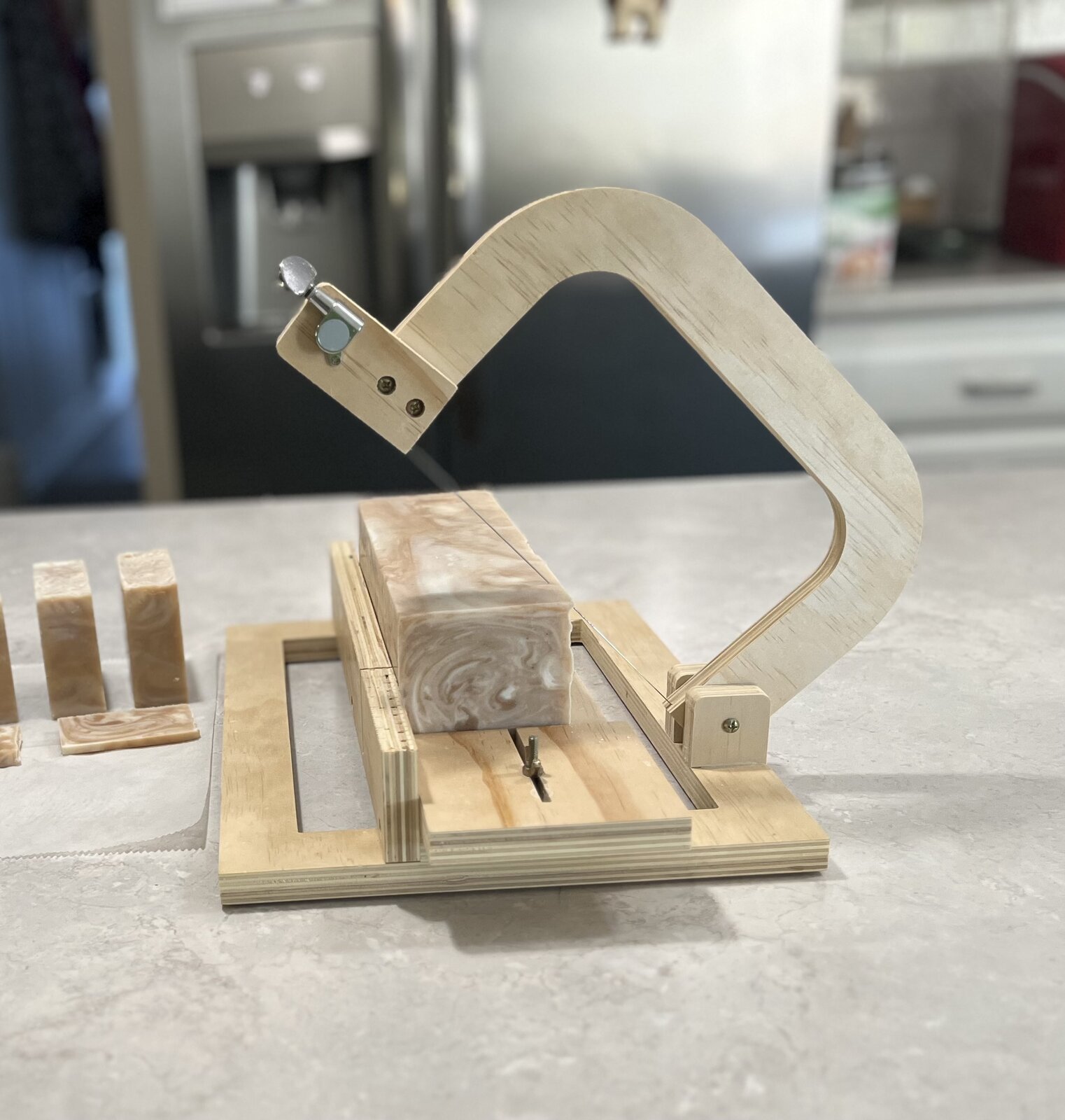 The wooden soap cutter, with a fresh loaf of soap ready to slice